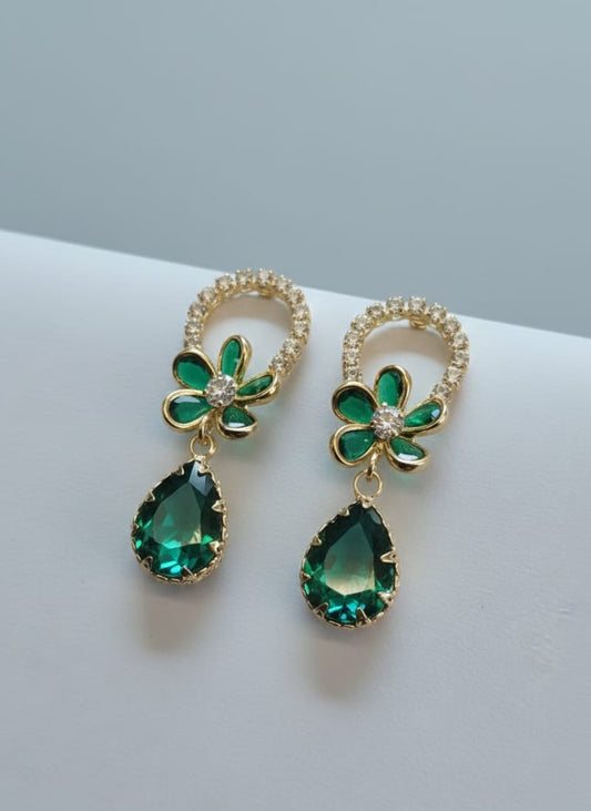 Pair of green gemstone earrings with gold accents on a light gray background
